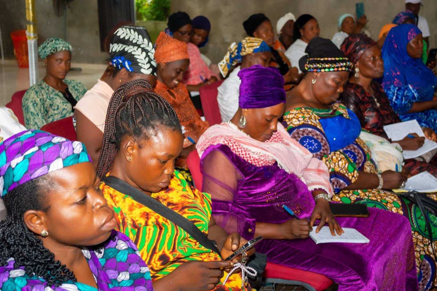 Women seated together taking notes during a Her Advantage financial literacy training session